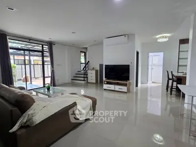Spacious modern living room with sleek design and pool view, perfect for family gatherings.