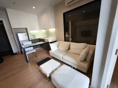 Modern living room with open kitchen layout and stylish furniture in a cozy apartment.