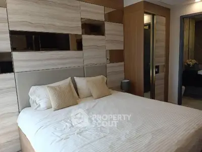 Luxurious bedroom with elegant wood paneling and plush bedding in modern apartment.