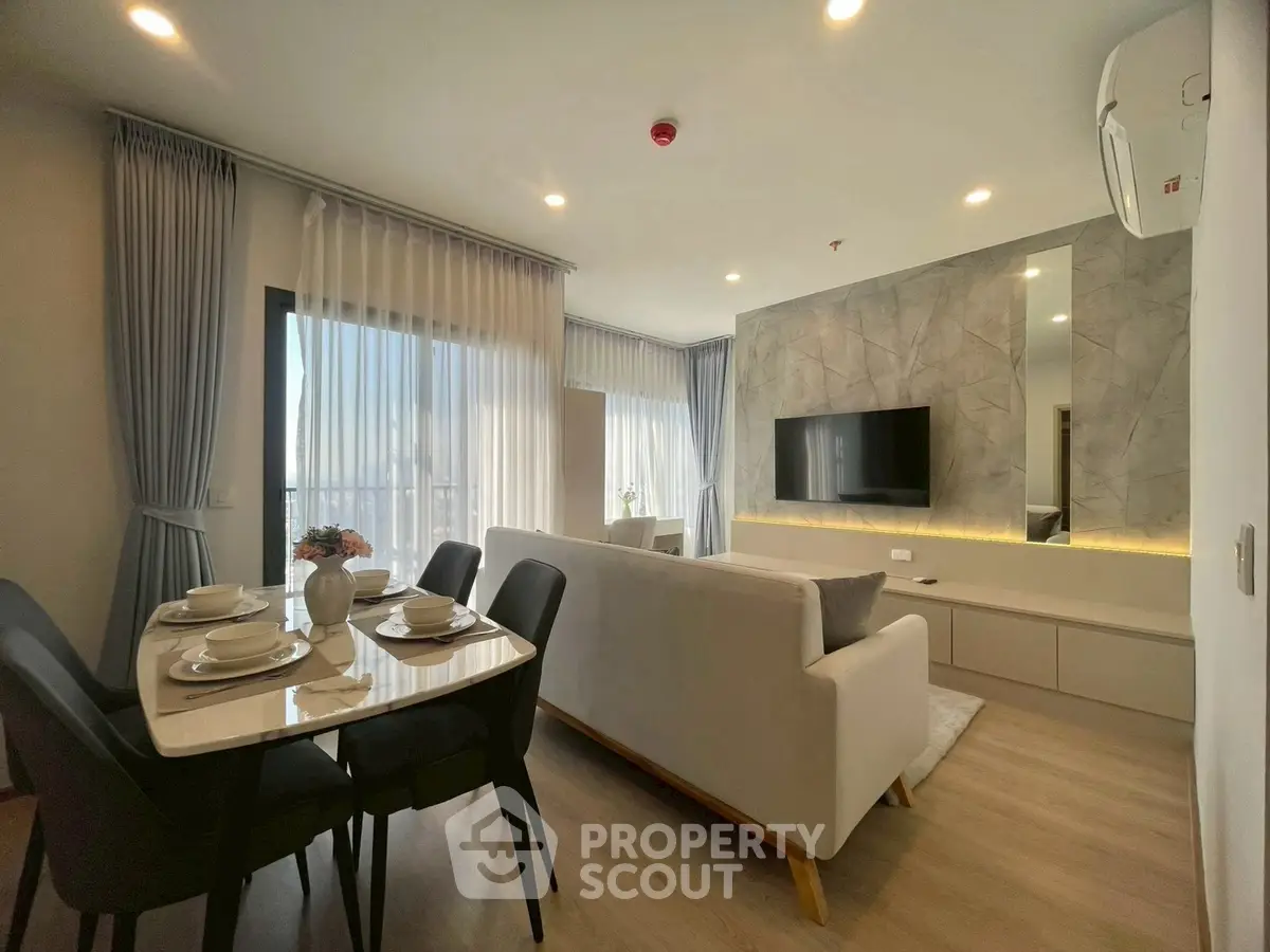 Modern living room with dining area and stylish decor in open layout apartment.