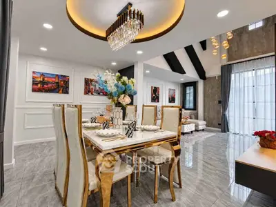 Luxurious dining and living area with elegant chandelier and modern decor