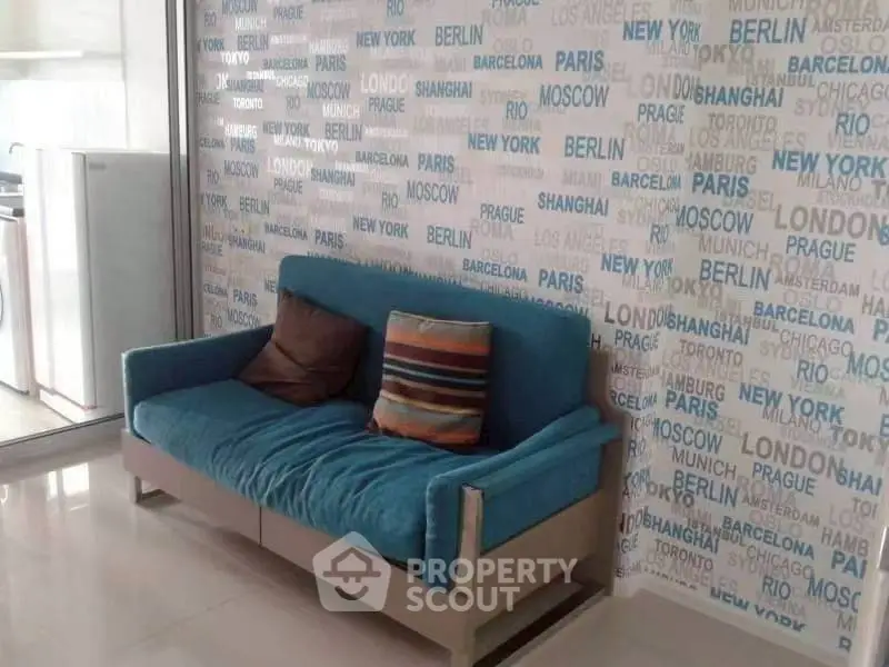 Stylish living room with vibrant blue sofa and city-themed wallpaper