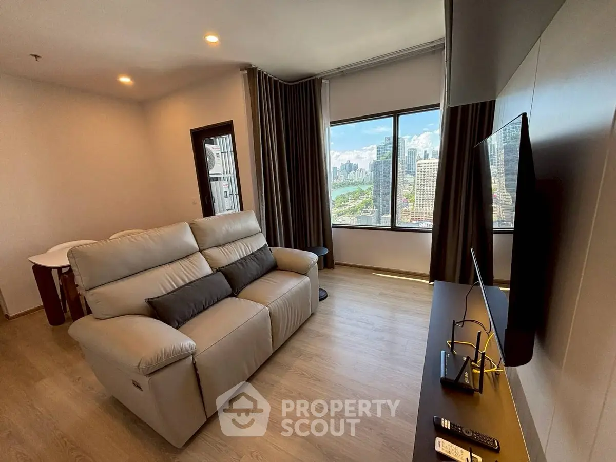 Modern living room with city view, featuring a cozy sofa and wall-mounted TV, perfect for urban living.