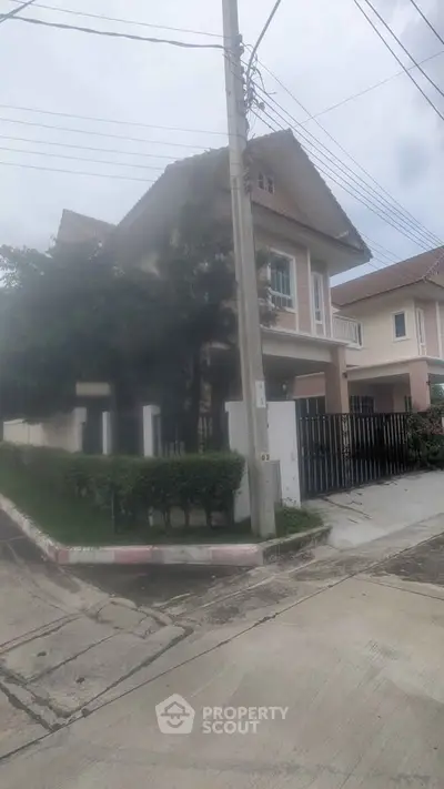 Charming two-story house with lush greenery and modern design in a serene neighborhood.