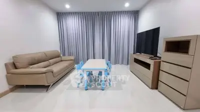 Modern living room with sleek furniture and large TV, perfect for family gatherings.