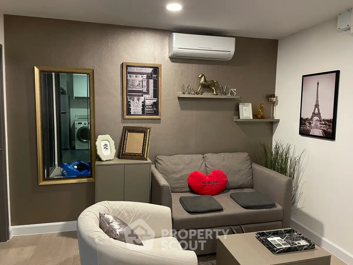 Cozy living room with modern decor and air conditioning, featuring a stylish sofa and elegant wall art.
