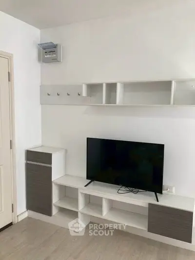 Modern living room with sleek TV stand and wall-mounted shelves in minimalist design.