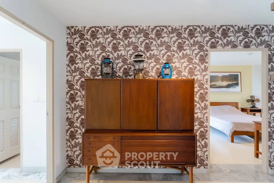 Stylish mid-century modern interior with vintage wooden cabinet and floral wallpaper