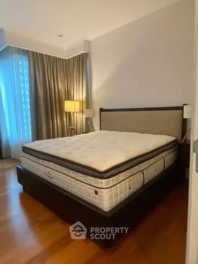 Spacious bedroom with elegant decor and large windows for natural light.