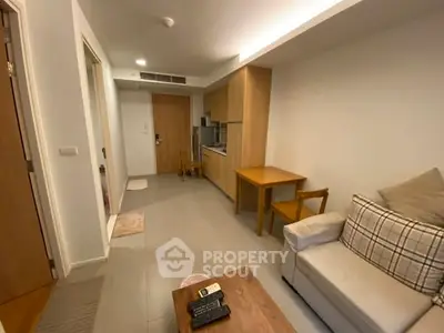Cozy living room with modern furniture and compact kitchen in a stylish apartment.