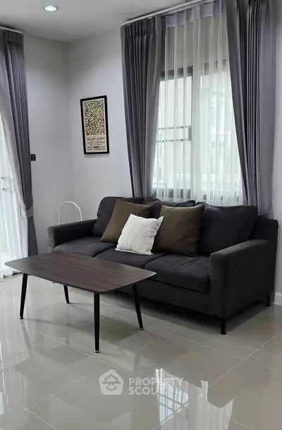 Modern living room with sleek sofa and elegant curtains, perfect for stylish urban living.
