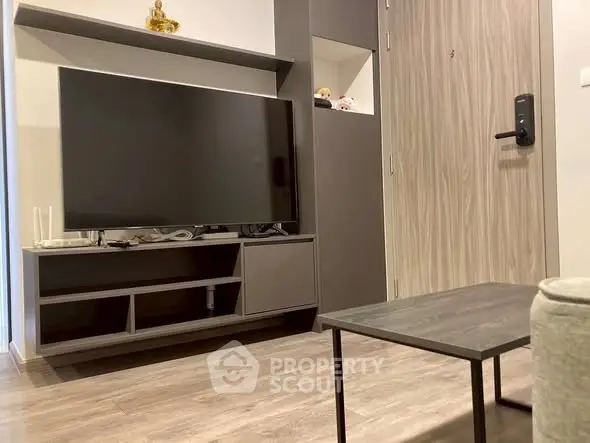 Modern living room with sleek TV setup and stylish wooden flooring.