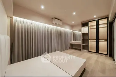 Spacious modern bedroom with built-in wardrobe and elegant lighting
