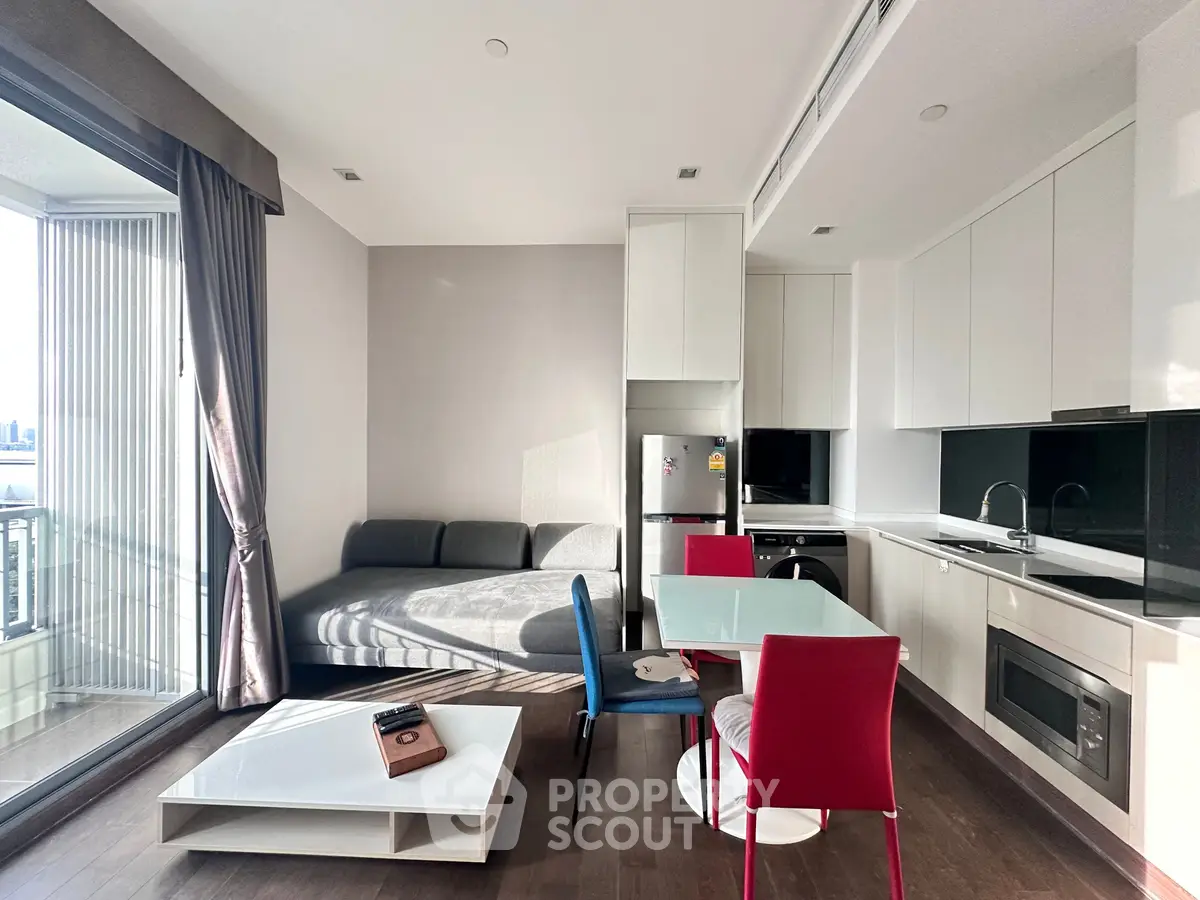 Modern open-layout living room with sleek kitchen and balcony view