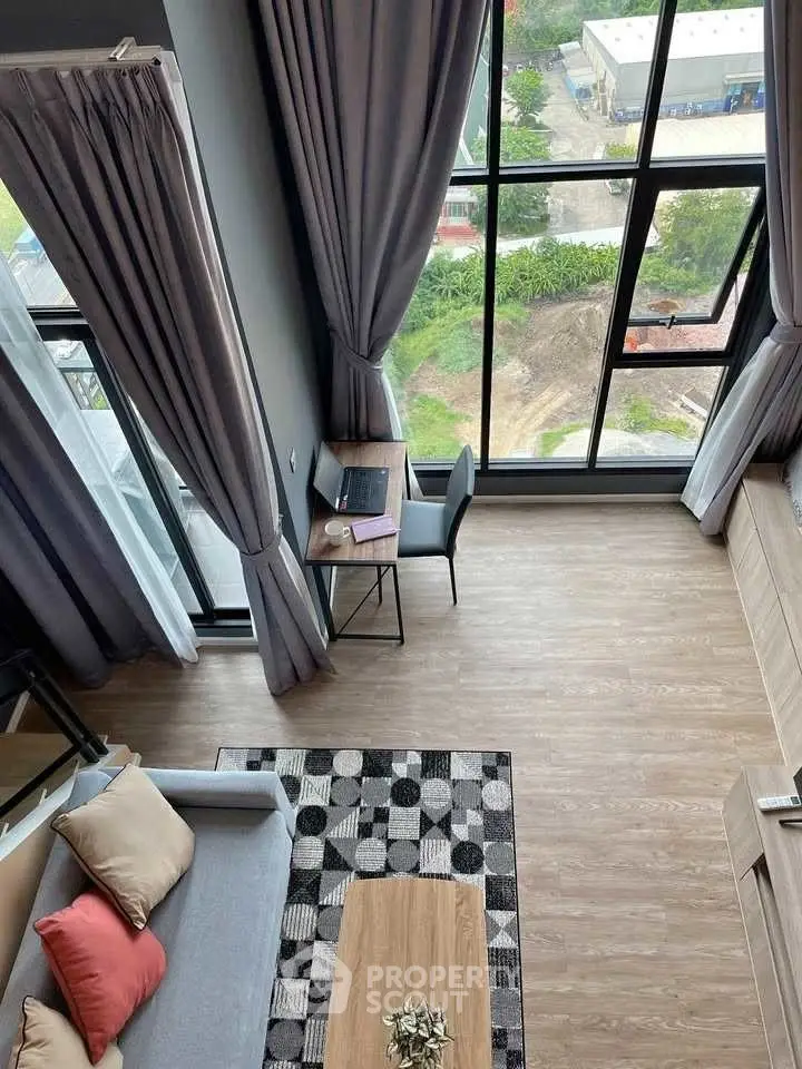 Modern loft-style living room with large windows and stylish decor