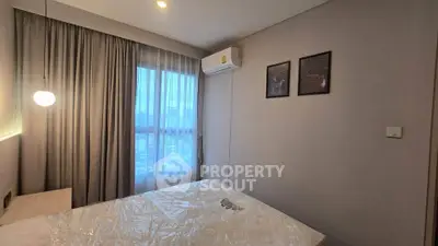 Modern bedroom with large window and air conditioning in a stylish apartment.