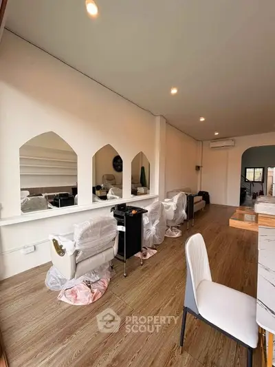 Spacious modern interior with wooden flooring and stylish seating, ideal for commercial use.