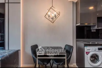 Modern kitchen with sleek design, featuring a dining area and washing machine for convenient living.