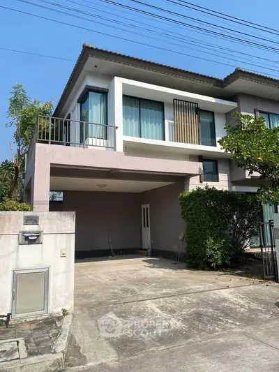 Modern two-story house with spacious driveway and lush greenery, perfect for family living.