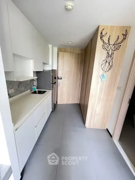 Modern kitchen with sleek cabinetry and stainless steel appliances in a stylish apartment.