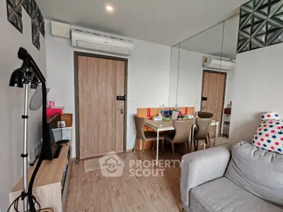 Modern living room with cozy sofa and dining area, featuring stylish decor and air conditioning.