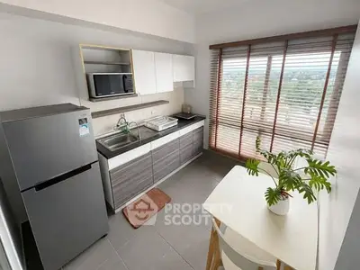 Modern kitchen with sleek cabinets, large window, and dining area offering scenic views.