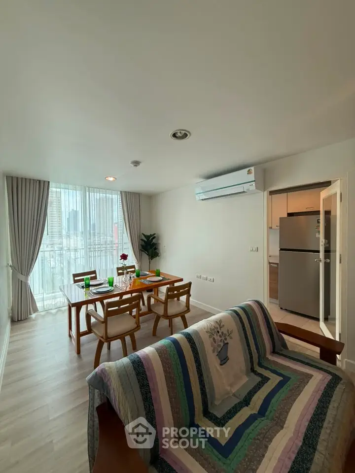 Spacious living room with dining area and modern decor in a bright apartment.