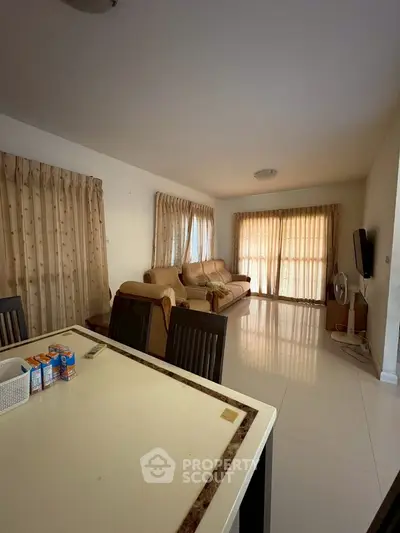 Spacious living room with elegant curtains and modern furniture, perfect for relaxation and entertainment.
