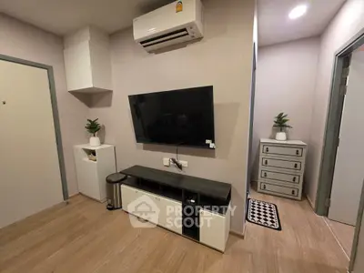 Modern living room with sleek TV setup and stylish decor in a cozy apartment.