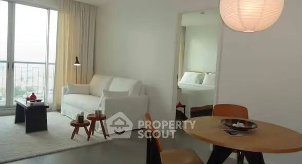 Modern living room with cozy seating and dining area in a bright apartment.