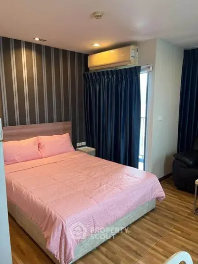 Cozy bedroom with pink bedding and modern decor in a stylish apartment.
