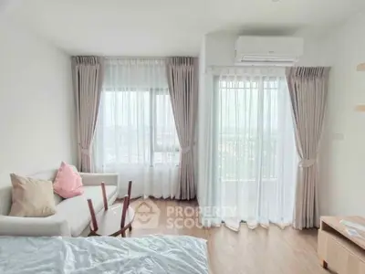 Bright and airy bedroom with large windows and modern furnishings, offering a serene city view.