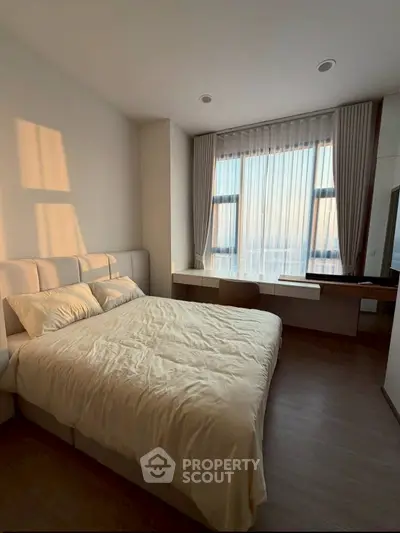 Modern bedroom with large window and elegant decor, featuring a cozy bed and stylish desk.