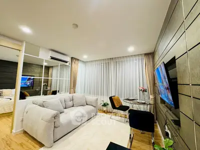 Modern living room with stylish decor and open layout, featuring a cozy sofa and wall-mounted TV.