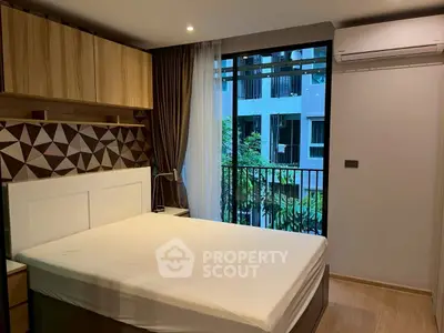 Modern bedroom with stylish decor and large window overlooking greenery.