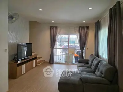Spacious living room with modern decor and large window for natural light.