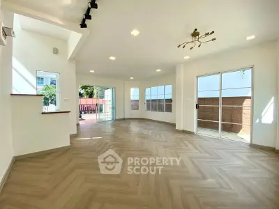 Spacious modern living room with large windows and elegant flooring