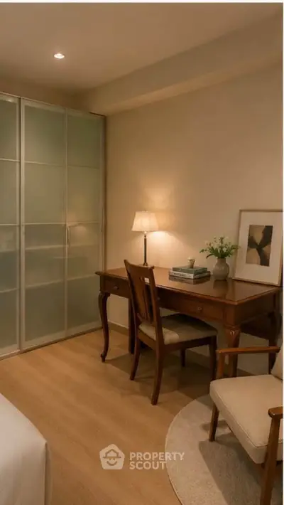 Cozy study area with elegant wooden desk and chair, soft lighting, and modern decor in a stylish apartment.