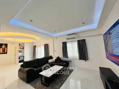 Modern living room with sleek black leather sofa and ambient lighting