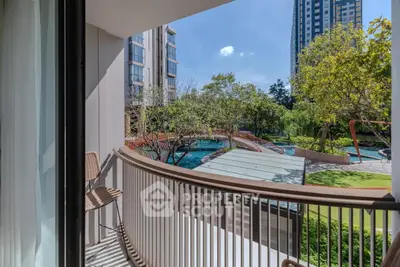 Stunning balcony view overlooking lush garden and modern pool area in urban setting