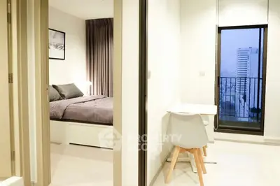 Modern apartment with cozy bedroom and city view balcony.