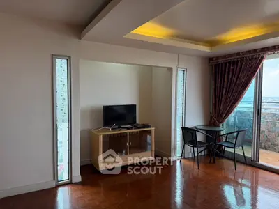 Spacious living room with balcony and city view, featuring modern decor and natural light.