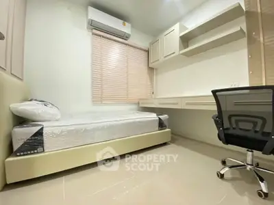 Modern bedroom with sleek design, featuring a single bed, built-in desk, and ergonomic chair.
