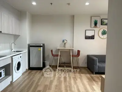 Modern apartment interior with kitchen and living area featuring wooden flooring and stylish decor.
