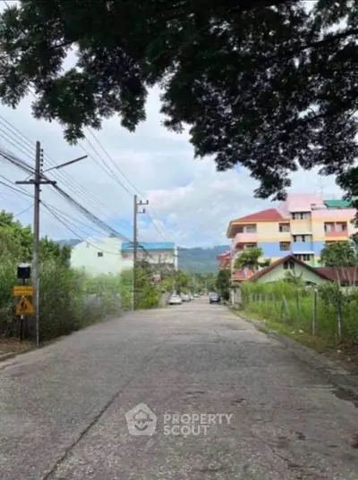 Charming suburban street view with colorful houses and lush greenery.