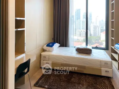 Modern bedroom with city view, featuring a cozy bed and built-in storage, ideal for urban living.