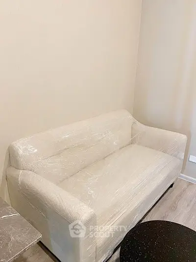 Cozy living room with a wrapped beige sofa and modern decor