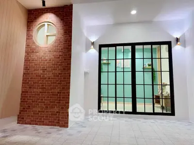 Modern interior with brick accent wall and large glass doors, perfect for stylish living spaces.