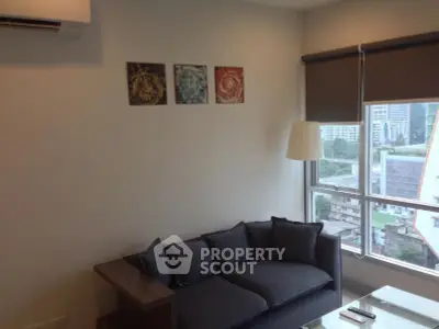 Modern living room with city view, stylish sofa, and wall art in a high-rise apartment.