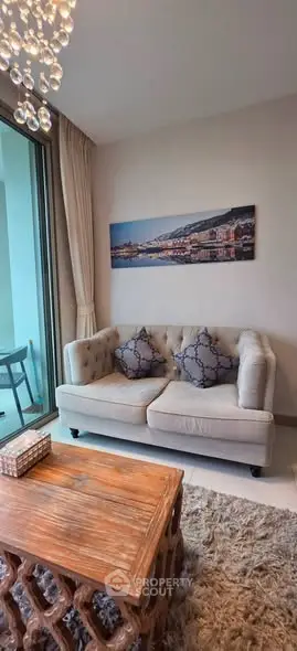 Charming living room with elegant sofa, wooden coffee table, and balcony view in modern apartment.
